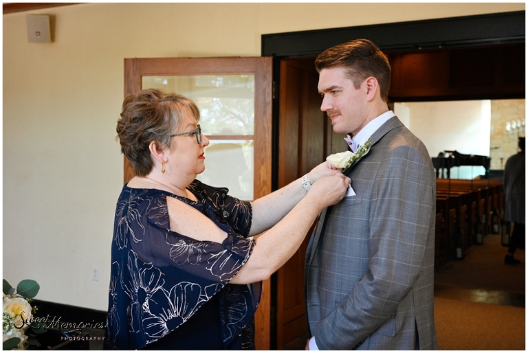 Mom putting on the groom's boutonniere at this Austin wedding.